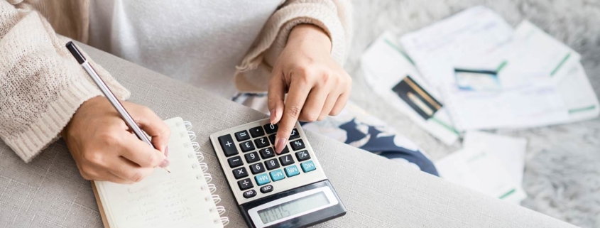 Image of a woman using a calculator to figure out personal finances