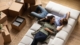 smiling couple resting on cozy couch with moving boxes