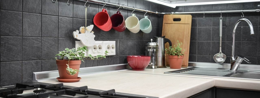 Small modern kitchen with rail system and kitchen utensils and houseplant