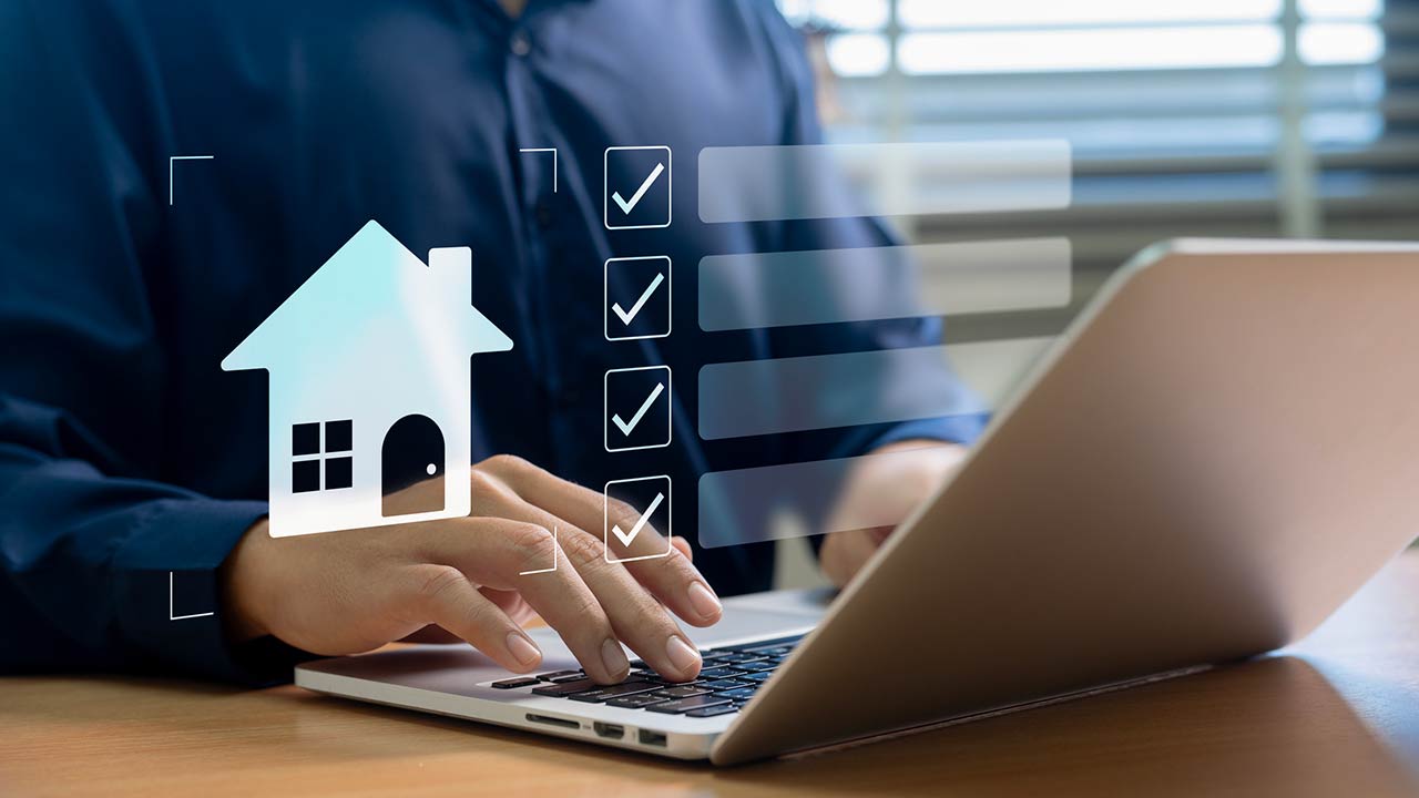 A professional organizing real estate tasks on a laptop using a digital checklist