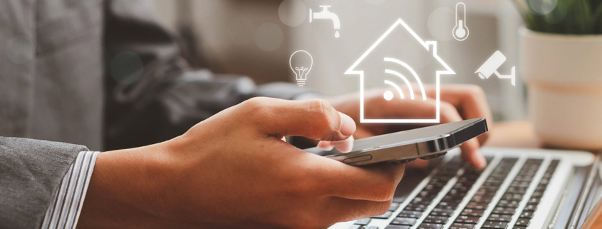Person using a smart home app on a phone and laptop